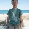 The same child from the previous image, now facing forward, wearing a blue T-shirt with a white whale shark design on the front.