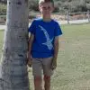 The same child from the previous image, now facing forward, wearing a blue T-shirt with a white whale shark design on the front.