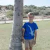 The same child from the previous image, now facing forward, wearing a blue T-shirt with a white whale shark design on the front.