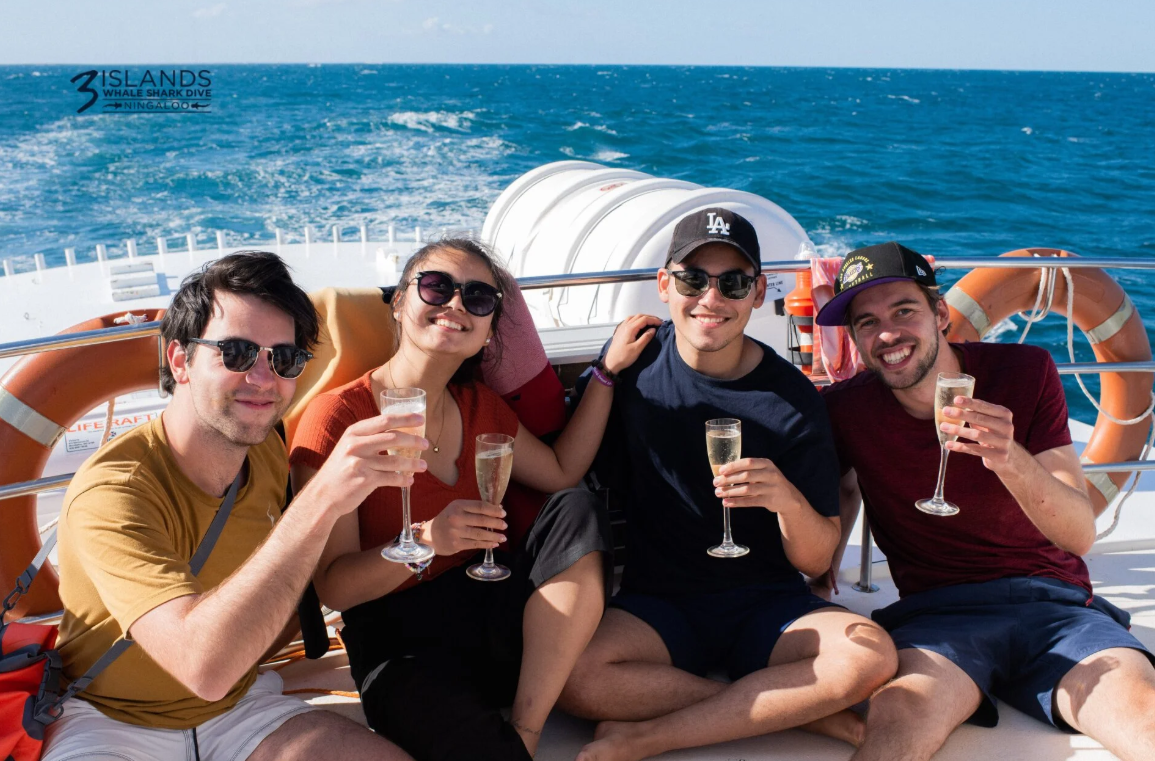 Guests relaxing with drinks aboard a private Ningaloo Reef charter