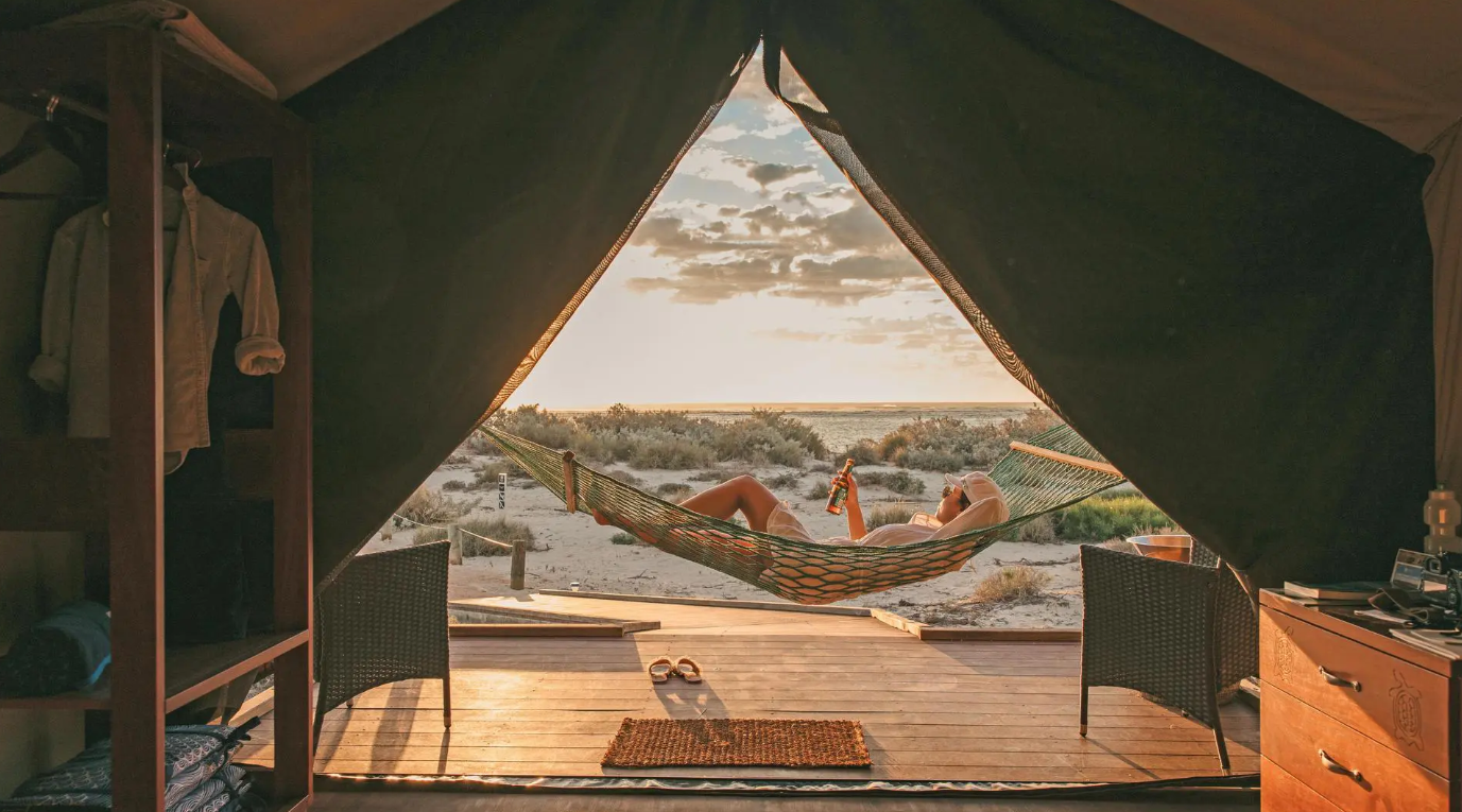 Sal Salis Ningaloo Reef Safari Camp Guest relaxing in a hammock outside a safari tent at Sal Salis Ningaloo Reef